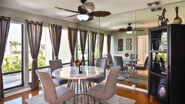 A dining area with a round table, chairs, and a ceiling fan. - Burnt Store Isles Golf Home, W/Hot Tub/King Bed/Fast WIFI/Unbeatable Location (Punta Gorda)