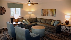 A living room with a sectional sofa, two armchairs, a coffee table, a ceiling fan, a clock, a lamp, and a painting on the wall. - 2 bdr, 2 baths, golf, spa, water park for FAMILY FUN in Virginia (Massanutten)