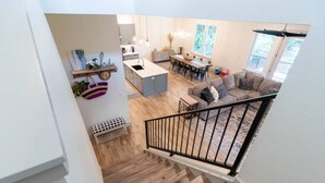 Un grand espace de vie comprenant un escalier, un coin repas et une cuisine.