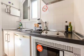 A kitchen with a built-in grill, a window, and a no-smoking sign. - Spacious, bright studio with a terrace and a view of the pool (Arona)