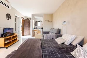 A bedroom with a bed, a desk, a chair, a television, and a wardrobe. - Spacious, bright studio with a terrace and a view of the pool (Arona)