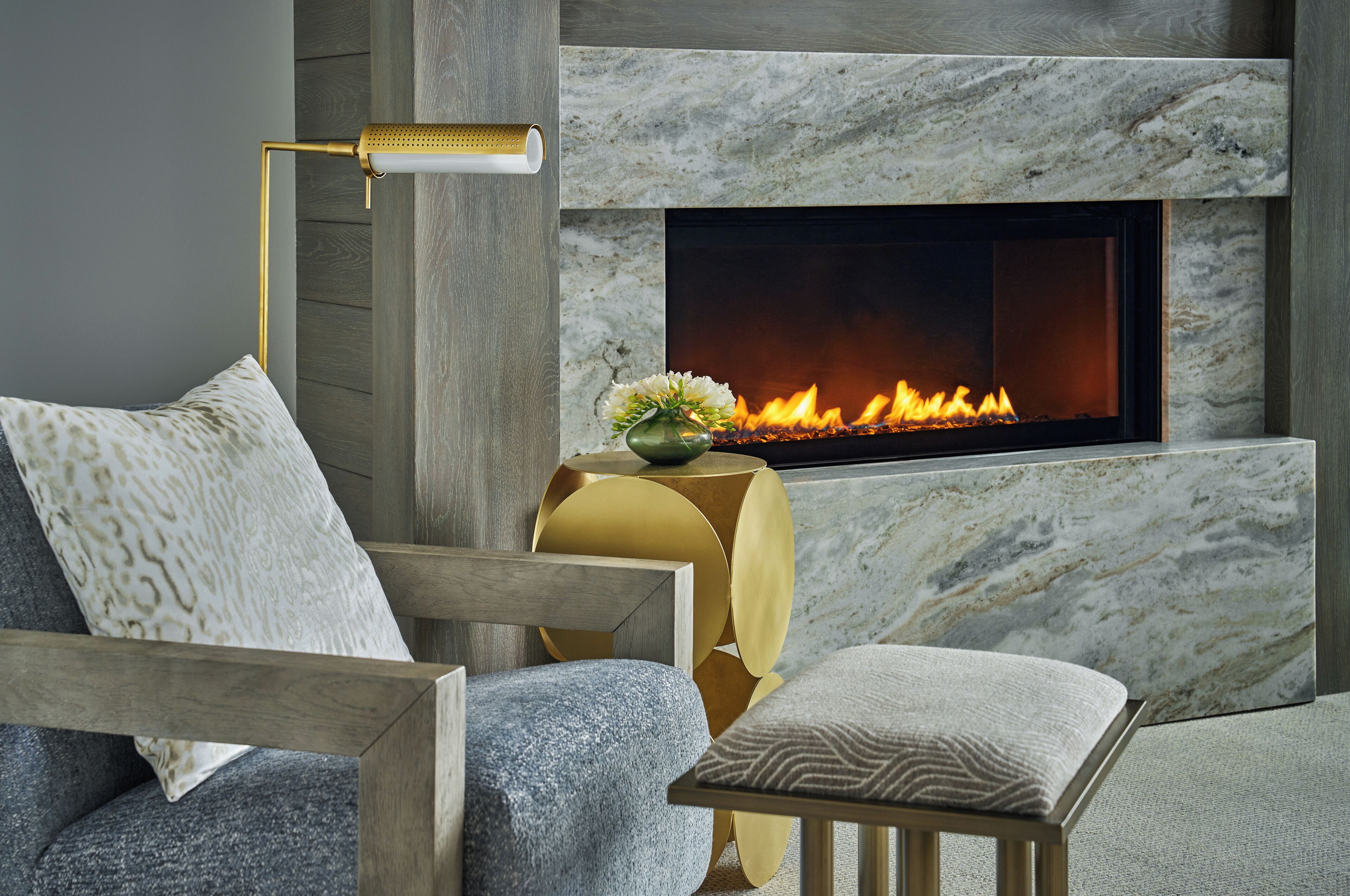 Una sala de estar moderna con chimenea, un sofá, una mesita auxiliar y una lámpara de pie.