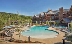 Alberca techada, alberca al aire libre y sombrillas en la alberca