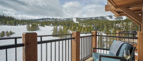 A balcony with a view of a snowy landscape and mountains.