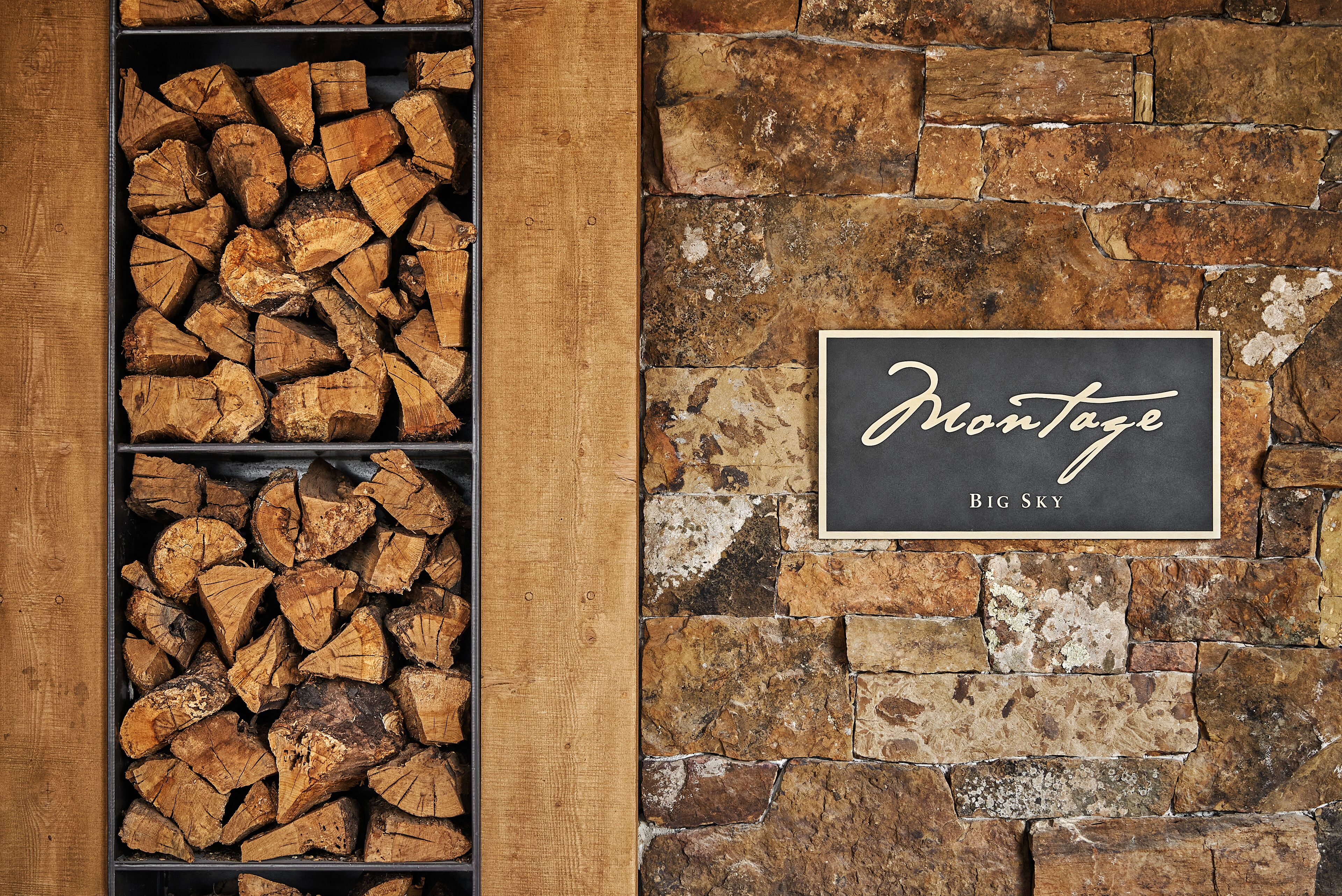 A fireplace with stacked firewood and a sign that reads "Montage Big Sky".