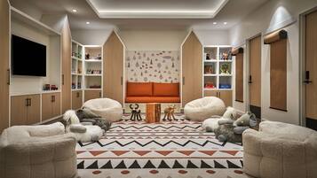 Relax in this cozy living space with a central sofa, bean bags, and a flat-screen TV.