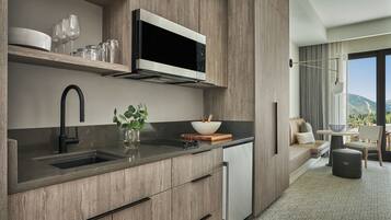 A modern kitchen with a built-in microwave, a sink, and a dining area with a view of the outdoors.