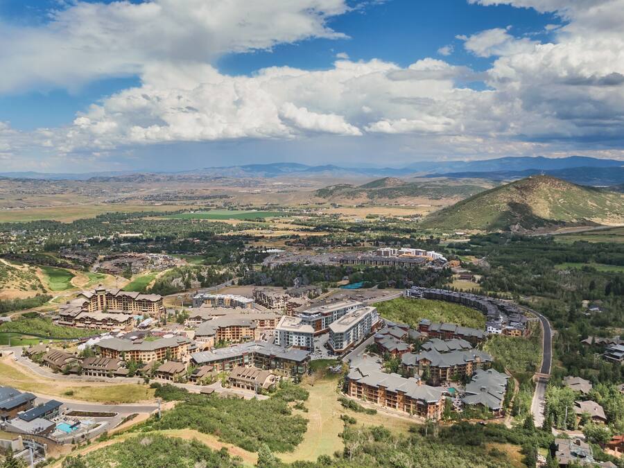 Un complexe hôtelier comprenant plusieurs bâtiments, une piscine et un paysage montagneux en toile de fond.
