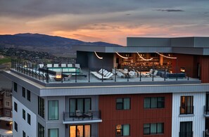 Eine Dachterrasse mit Liegestühlen, einem Pool und einer Bar.