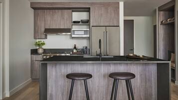 Una cocina moderna con una isla central, electrodomésticos de acero inoxidable y armarios de madera.
