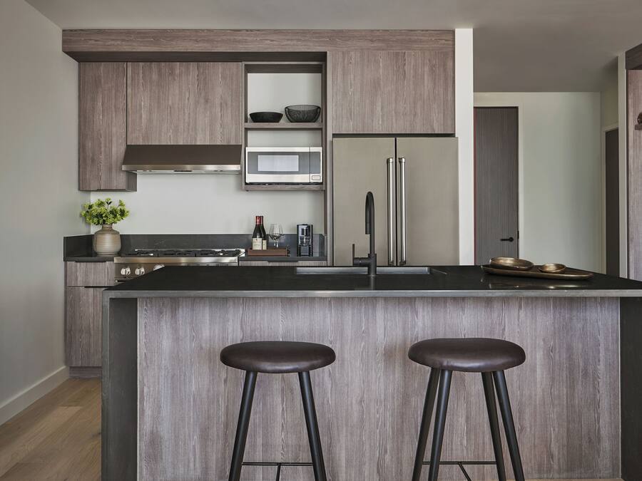 Una cocina moderna con una isla central, electrodomésticos de acero inoxidable y armarios de madera.