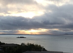 A coastal landscape with a view of the sea and a distant island. - Executive Accommodation with World Class Views (Coopers Beach)