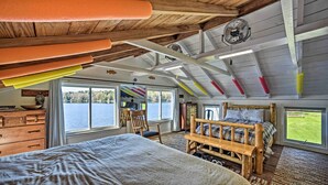 A bedroom with a large bed, wooden furniture, and a view of the outdoors. - BBQ Ready: Lakeside Milford Home w/ Paddleboat (Milford)