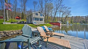 A lakeside cabin with a dock, Adirondack chairs, and a small red building. - BBQ Ready: Lakeside Milford Home w/ Paddleboat (Milford)