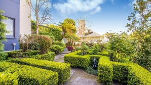 Un jardín bien cuidado con setos ordenados y una gran variedad de plantas.