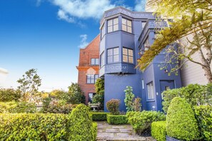 Stunning two-story building with a unique architectural style, set amidst beautifully manicured gardens.
