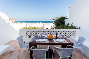 A table set for two with a view of the sea, white walls, and a lattice partition. - CoolHouses Algarve Luz | Villa 76 LBC (Luz)