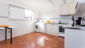 Una cocina compacta con lavadora, microondas y estufa.