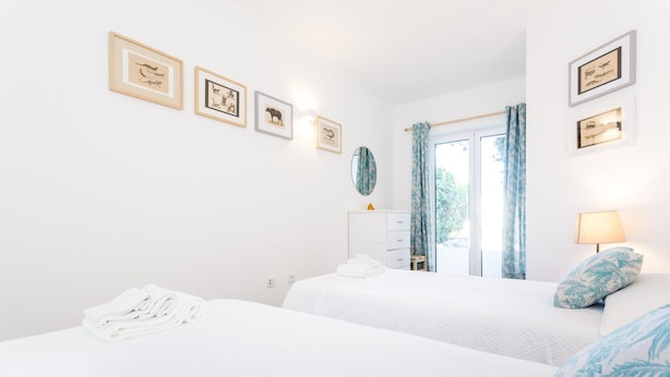 Una habitación de hotel con dos camas, un aparador, un espejo y cuadros en la pared.