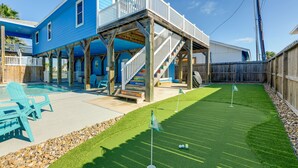Una casa azul con una terraza de madera y una piscina.