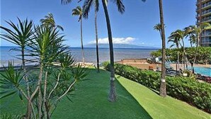 Un complexe hôtelier doté d’une piscine, de palmiers et offrant une vue sur l’océan.
