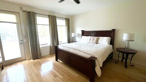 A spacious bedroom with a large bed, a ceiling fan, and a view through the window. - Town home in the Marina  38 HT (Laguna Vista)