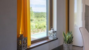 A room with a window, a white cabinet, a potted plant, and two decorative lanterns. - Melograno by Interhome (Lago di Vico)