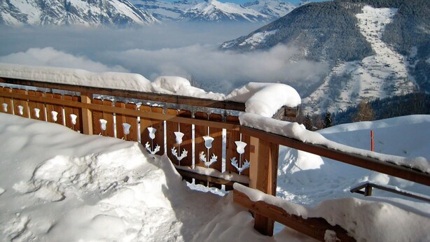 A wooden fence with snow accumulation, overlooking a mountainous landscape with snow-covered peaks and a valley below. - Wonderful private villa for 8 people with WIFI, terrace, pets allowed and panoramic view (La Tzoumaz)
