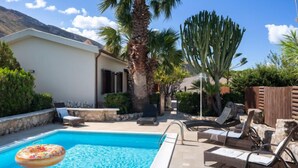A swimming pool with lounge chairs and a palm tree. - Nicole con Dependance by Interhome (Castellammare del Golfo)