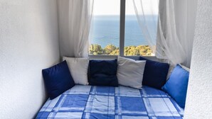 A bedroom with a large window, white curtains, and a bed with blue and white bedding. - Villa with pool located in the south of Spain (Salobreña)