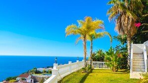 A coastal property with a white fence, a grassy lawn, and a view of the sea. - Villa with pool located in the south of Spain (Salobreña)