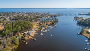 An aerial view of a coastal town with a marina, houses, and a bridge in the distance. - Waterfront Views & Boat Slip, Blackwell Point #C (Oriental)