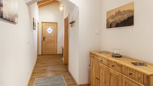 Ein Flur mit Holzboden, einem Holzschrank und einer Tür am Ende.