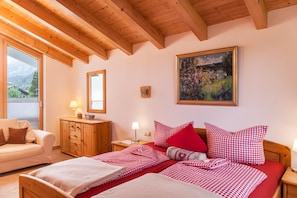 Une chambre à coucher comprenant un lit, une tête de lit en bois, une table de chevet, une commode, un miroir et un tableau accroché au mur.