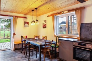 Spiseområde med et træbord, stole og en moderne ovn.