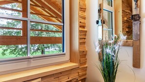 A wooden interior with a window, a bench, and a potted plant. - Chalet Rauschn with mountain view with shared sauna, terrace, balcony; pet friendly (Farchant)