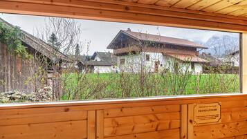 Een houten interieur met uitzicht op traditionele huizen en een stenen muur.