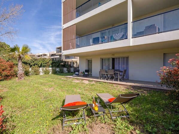 A modern apartment with a balcony, outdoor seating area, and a view of the cityscape. - Golfe Horizon by Interhome (Fréjus)