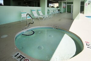 A swimming pool with lounge chairs and a diving board.