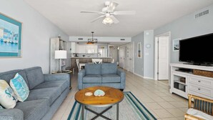 A living room with a sofa, a coffee table, and a television. - Welcome to PARADISE POINTE, your ultimate oceanfront retreat in North Myrtle Beach (North Myrtle Beach)
