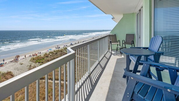 A balcony with a view of the beach and ocean. There are chairs and a table on the balcony. - Welcome to PARADISE POINTE, your ultimate oceanfront retreat in North Myrtle Beach (North Myrtle Beach)