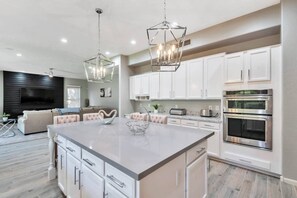A modern kitchen with white cabinets, stainless steel appliances, and a central island. - Backyard Oasis w/ Private Heated Pool & TV, Pool Table, Arcade Game, Near Golf, Dining & Mayo Clinic (Scottsdale)