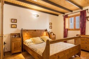 A wooden bed with a headboard, a nightstand, a dresser, and a window with curtains. - Holiday Home ‘Casa La Huertecilla’ with Private Pool (La Sorruenda)