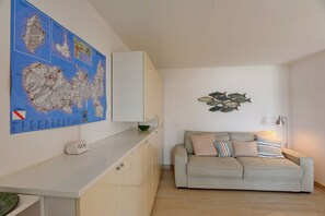 Una habitación con un mapa en la pared, un sofá, una lámpara y una mesita.