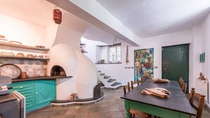 Een keuken met een inbouwoven, een eettafel met stoelen en een trap die naar een ander niveau leidt.