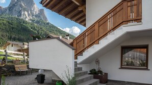 A modern house with a wooden staircase, a white exterior, and a mountain view. - Apartment 'Kristiania Type A2' with Mountain View, Sauna, Balcony & Garden (Siusi allo Sciliar (BZ))