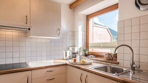 A kitchen with a window, a sink, cabinets, and a countertop. - Apartment 'Kristiania Type A2' with Mountain View, Sauna, Balcony & Garden (Siusi allo Sciliar (BZ))