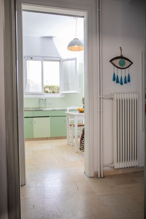 Enter a well-appointed kitchen with a white countertop, green cabinets, and a pendant light above.