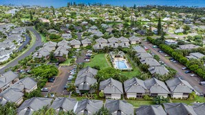 Zona residencial con casas, piscina y vista al océano.