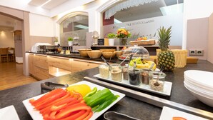 A hotel kitchen with a buffet setup, including various food items and condiments on display.